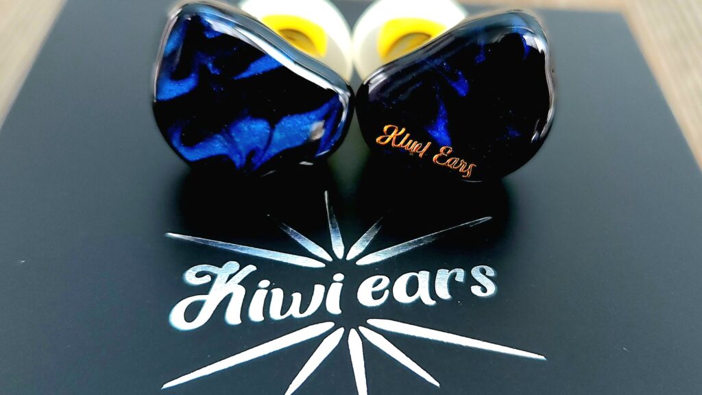 The Kiwi Ears Cadenza next to the Kiwi Ears Logo