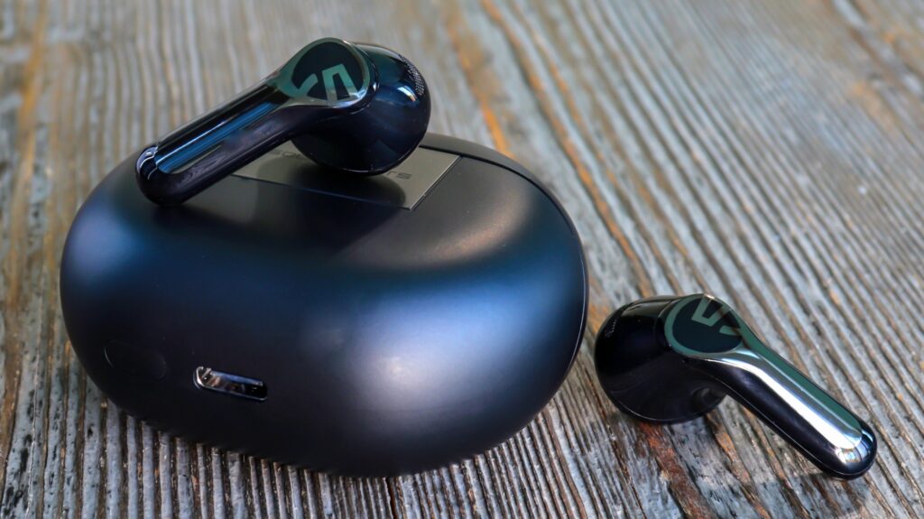 Soundpeats Air6 HS sitting on their charging case